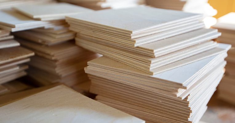 Contrachapado de madera de albasia apilado en paneles listos para uso en carpintería.